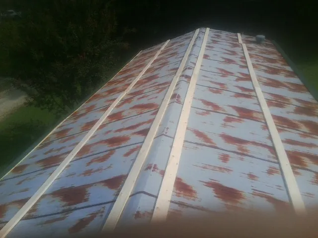 Rusted metal roof panels with new wood purlins before replacement — Storm Damage Roof Repair in Etna by Roofing Brothers